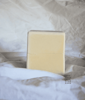 Two halves of a True Dish Block Soap (Coconut Oil) spinning on a white background.