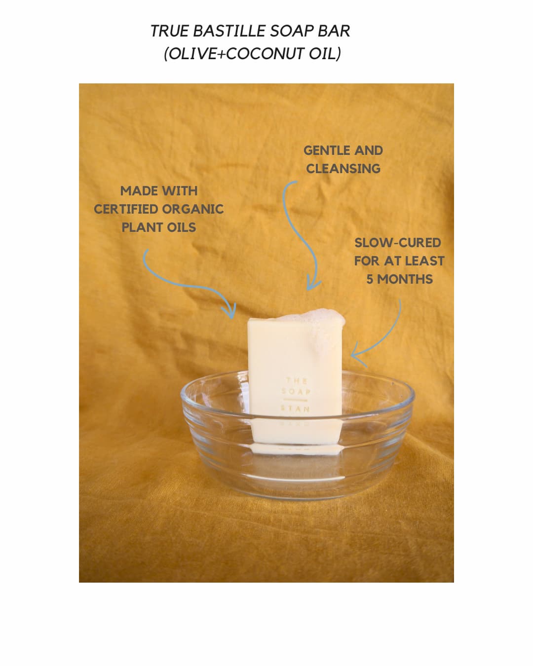 True Bastille Soap Bar in a glass bowl on yellow background. Text reads: Made With Certified Organic Plant Oils, Gentle And Cleansing, Slow-Cured For At Least 5 Months.
