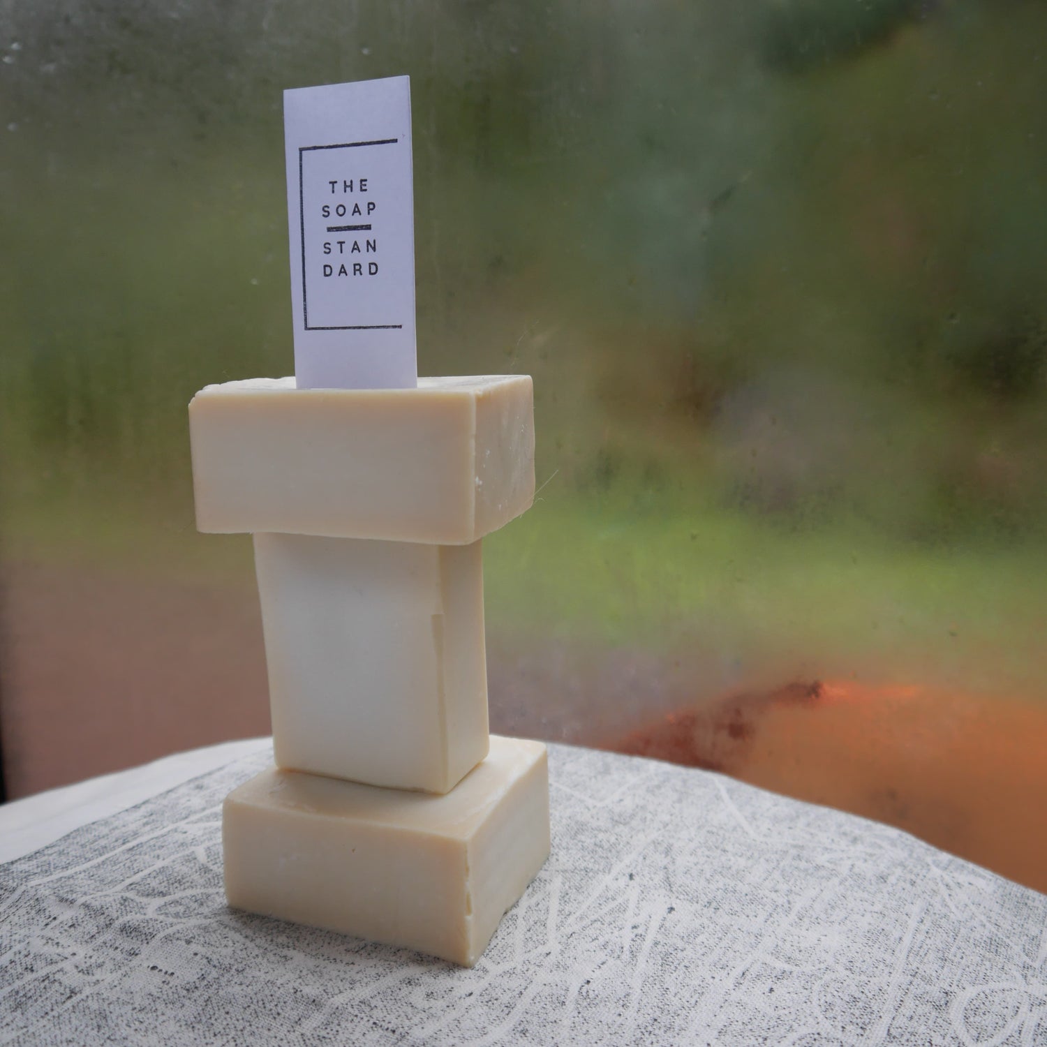 Trio of True Castile Soap Bars stacked on top of each other near a window