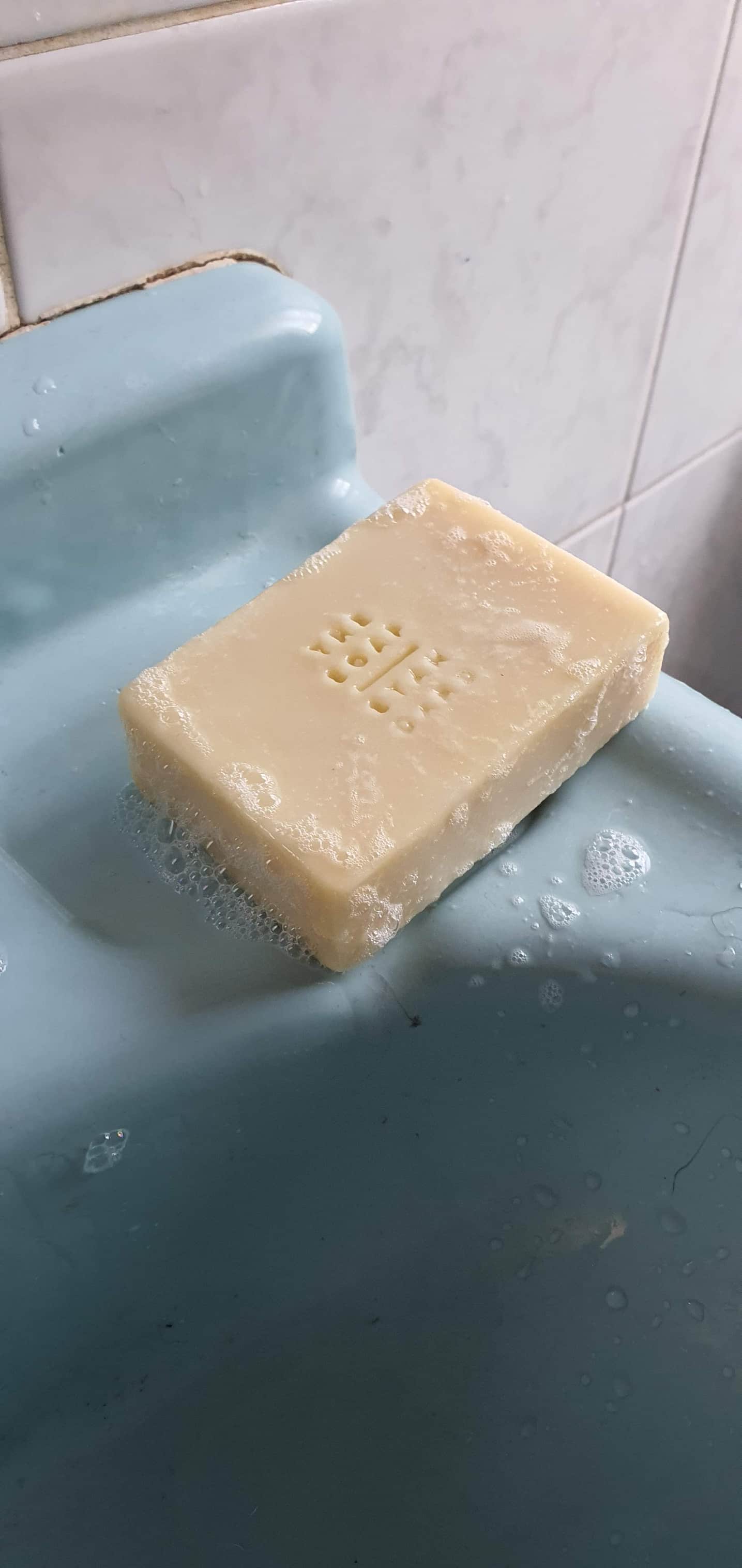 Cream coloured soap bar stamped with The Soap Standard logo on blue sink